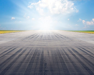 Blick auf eine Startbahn und einen blauen sonnigen Himmel.