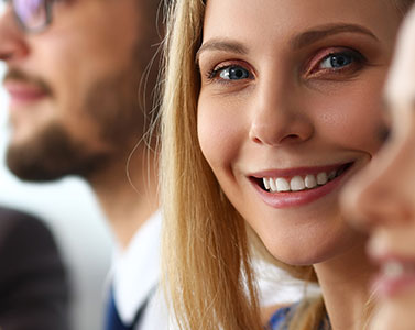 Eine junge Frau mit einem Laptop unter dem Arm geht zielstrebig eine Treppe nach oben