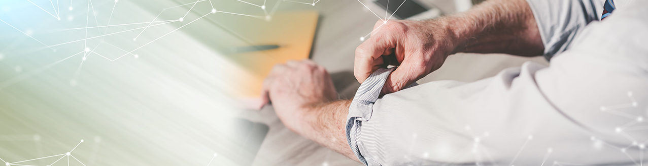 EineFrau mit einer weißen Bluse hält eine aufgeklappte Brille in den Händen